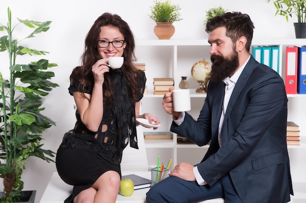 Pause café avec un collègue. Homme et femme conversation agréable pendant la pause-café. Discuter des rumeurs de bureau. Demandez des recommandations. L'heure du café pour se détendre. Des collègues de couple se détendent avec du café.