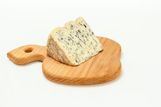 Pause de Fourme d'Ambert, un fromage bleu français mi-dur sur une planche à découper en bois avec la surface blanche