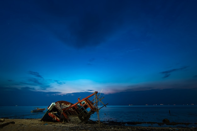 Épave de bateau de pêche sur la plage, coucher de soleil