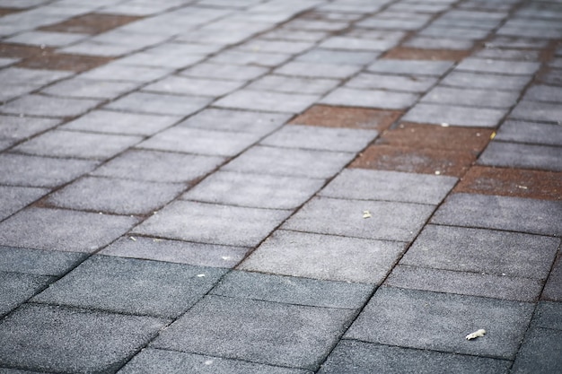 Pavé gris, passerelle piétonne, chaussée en gros plan, la texture, vue de dessus. Fond de sol en pierre au carré en brique de ciment. Dalles de pavage en béton. Dalles de pavage