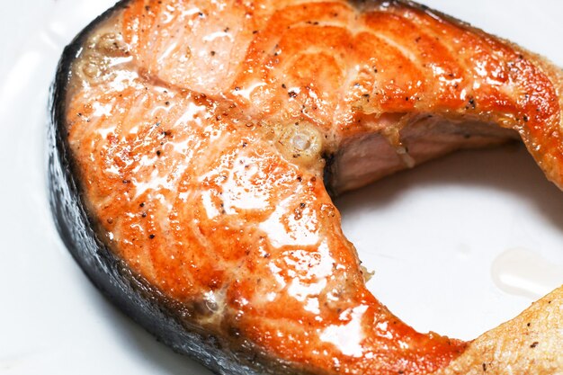 Pavé de saumon appétissant cuit sur une assiette blanche comme neige. Fermer.