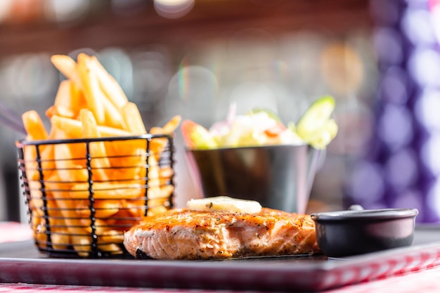 Pavé de saumon avec salade et frites au restaurant américain