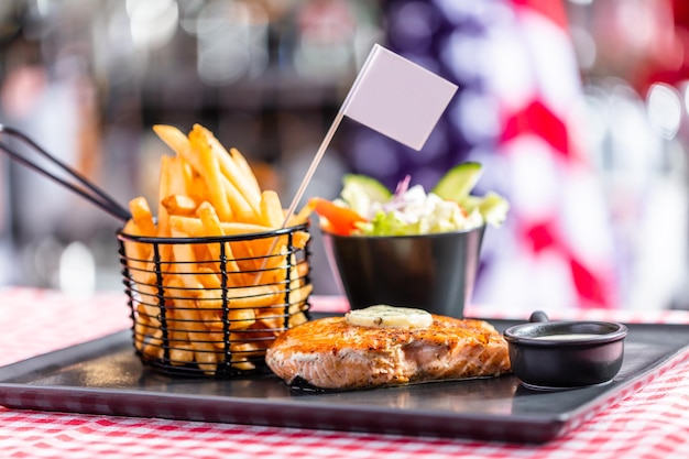 Pavé de saumon avec salade et frites dans un restaurant américain