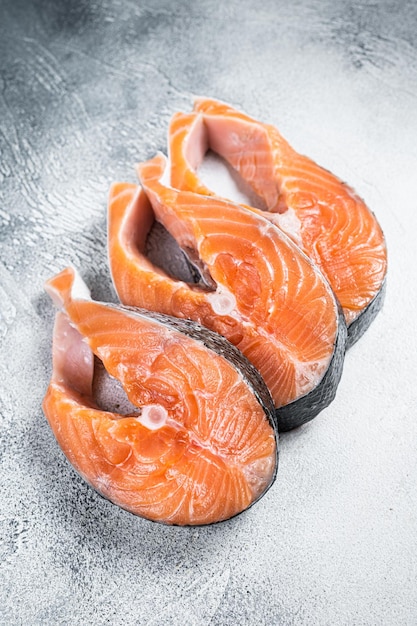 Pavés de saumon ou de truite, poissons crus préparés pour la cuisson. Fond blanc. Vue de dessus.