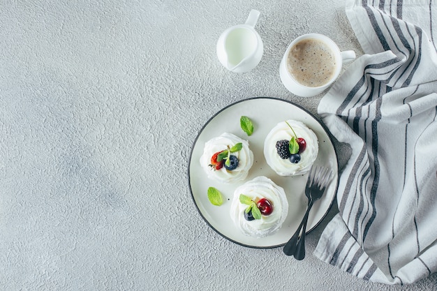 Pavlova de dessert de meringue avec des baies fraîches sur une assiette.