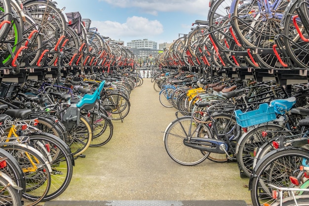 Photo pays-bas. journée chaude à amsterdam. grand parking à vélos sur deux niveaux près de la gare centrale d'amsterdam