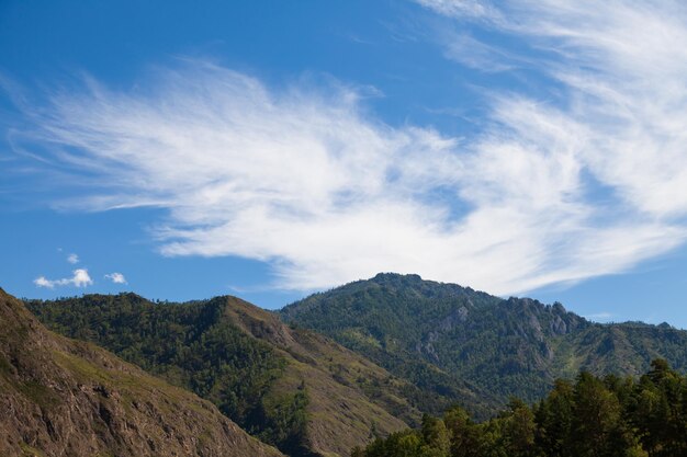 Photo paysage aérien avec des montagnes, des arbres verts, une route de campagne et une rivière sous un ciel bleu et des nuages en été