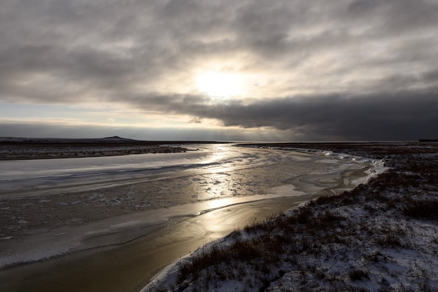 Paysage arctique en hiver. Petite rivière avec de la glace dans la toundra.