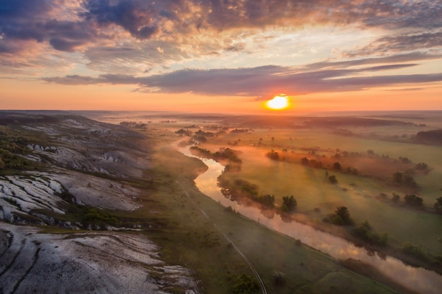 Paysage au lever du soleil avec brouillard, rivière et collines crayeuses