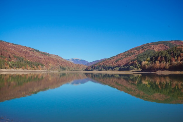 Paysage d'automne dans les montagnes avec rivière et arbres colorés en toile de fond