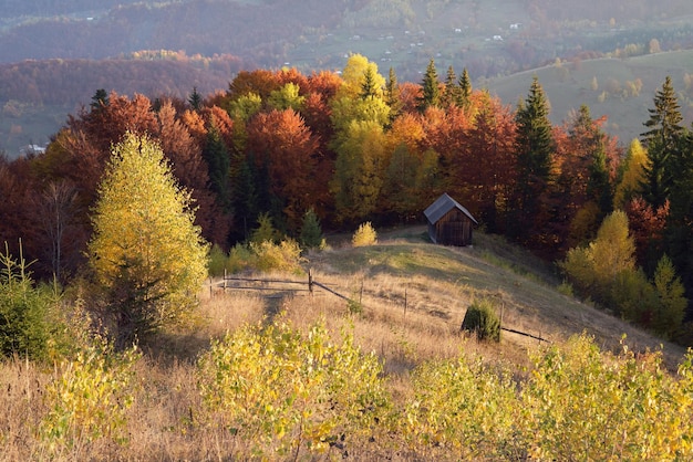 Paysage d'automne avec une maison en bois dans les montagnes