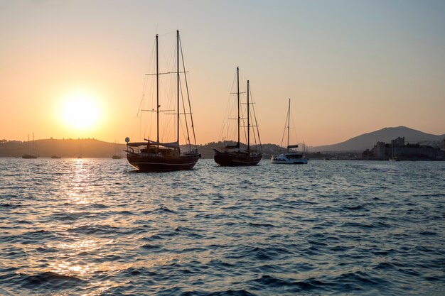 Paysage avec des bateaux à voile dans la baie de la marina au coucher du soleil.