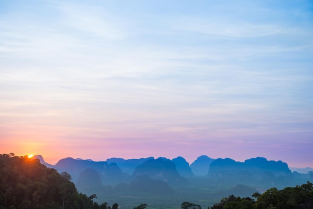 Paysage avec beau coucher de soleil spectaculaire et silhouette de montagnes bleues à l'horizon, Thaïlande