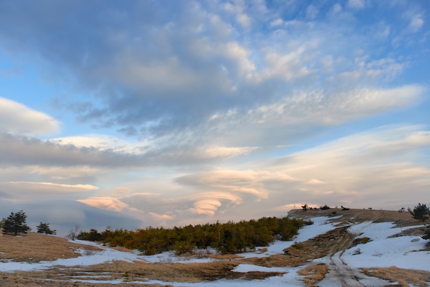 Paysage avec de beaux nuages lenticulaires dans les montagnes au coucher du soleil