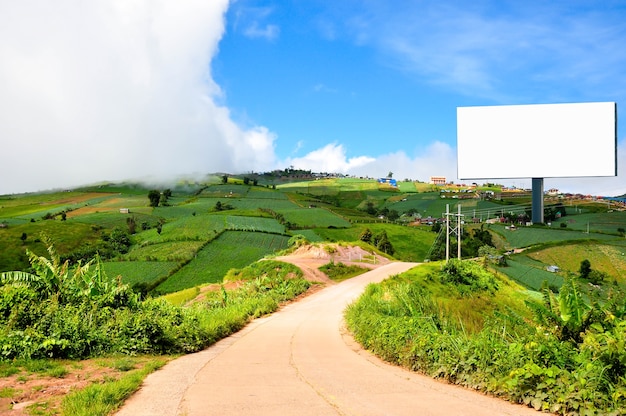 Photo le paysage de la belle campagne avec un panneau d'affichage vide pour la publicité