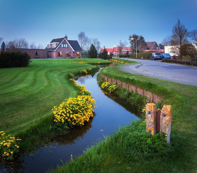 Paysage avec belle maison reflétée dans le canal d'eau au crépuscule