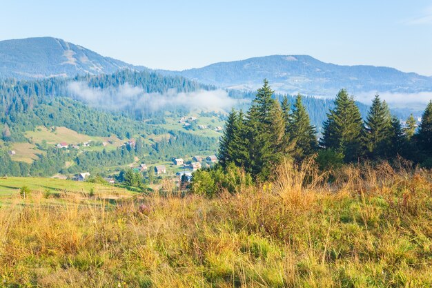 Paysage de campagne d'automne avec village à flanc de montagne