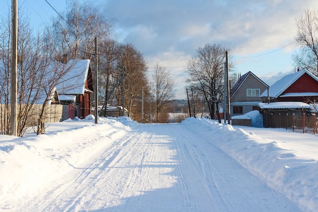 Paysage de campagne d'hiver. Route d'hiver avec des maisons en bois en Russie