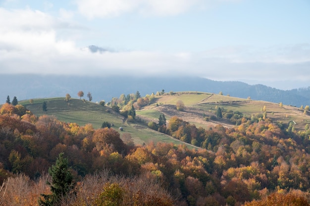 Paysage des Carpates en octobre collines et chaîne de montagnes par temps chaud et ensoleillé avec des nuages bas dans le ciel en automne