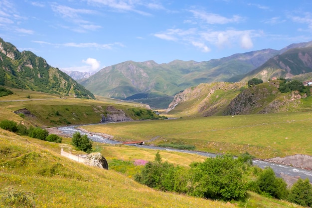 Paysage coloré avec de hautes montagnes belle rivière sinueuse forêt verte ciel bleu