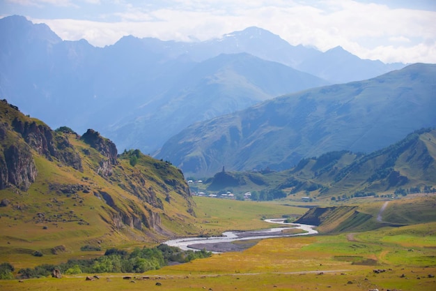 Paysage coloré avec de hautes montagnes belle rivière sinueuse forêt verte ciel bleu