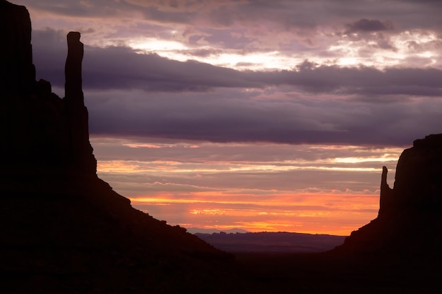 Paysage coloré de lever de soleil dans la vallée de monument avec la silhouette des buttes