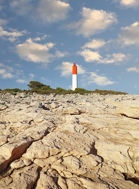 Paysage de côte de la mer rocheuse avec phare sur ciel bleu clair, low angle view