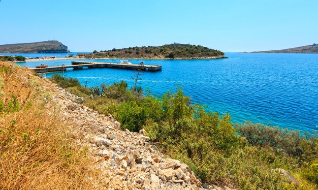 Paysage côtier d'été avec jetée dans la baie (Hemara, Albanie).