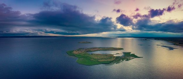 Paysage de coucher de soleil d'été rural avec petite île de rivière et vue panoramique aérienne de fond naturel de ciel coloré dramatique