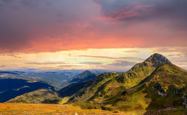 Paysage de coucher de soleil de hautes montagnes sous un ciel de soirée coloré et vibrant.