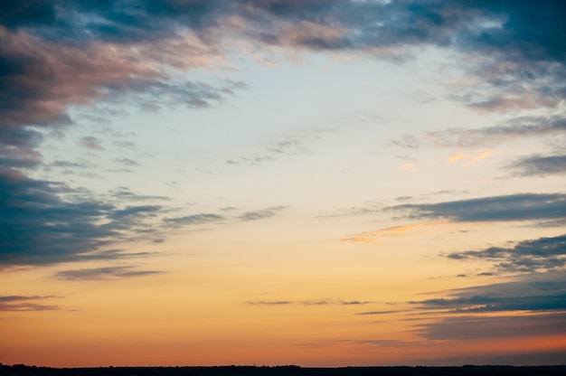 Paysage de coucher de soleil intéressant. Les nuages bleus divergent devant le ciel rouge. Moment fascinant.