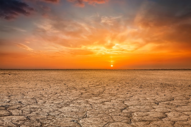 Photo paysage coucher de soleil sol terre fissurée