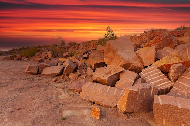 Un paysage désertique avec des rochers et d'énormes pierres au premier plan pris dans une carrière de granit en Ukraine