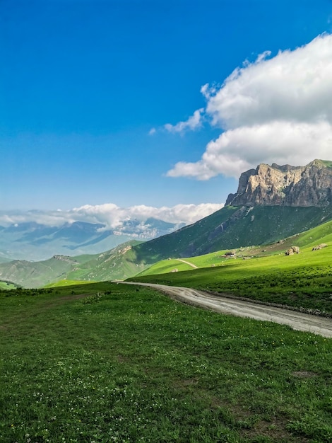 Le paysage du col vert d'Aktoprak dans le Caucase la route et les montagnes sous les nuages gris Russie