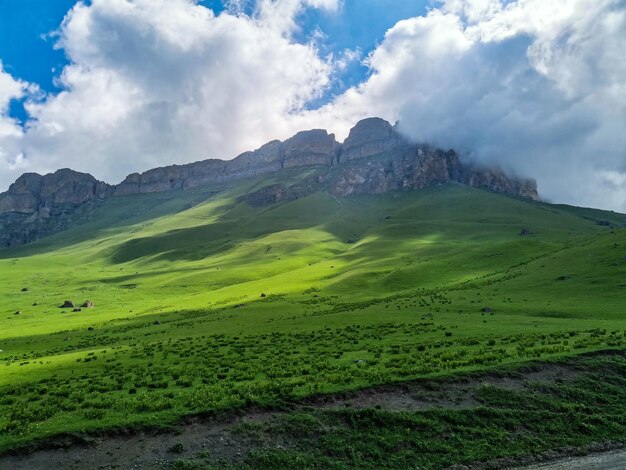 Le paysage du col vert d'Aktoprak dans le Caucase la route et les montagnes sous les nuages gris Russie