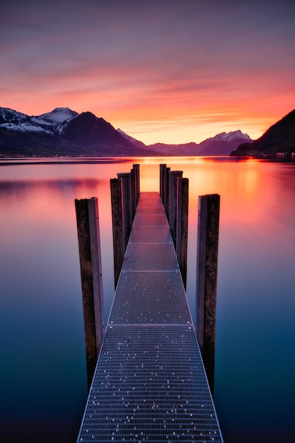 Photo paysage du lac violet avec des montagnes et une jetée