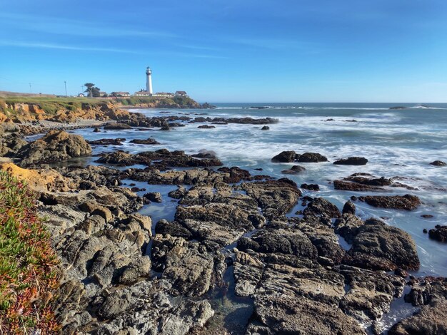 Le paysage du phare de Pigeon Point depuis les falaises de Pidgeon Point ciel bleu côte rocheuse en premier plan