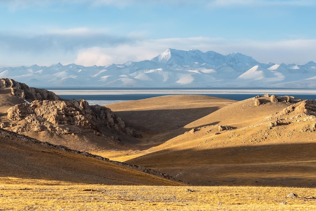 Paysage du plateau du Tibet du lac sacré et de la montagne enneigée au crépuscule à Namtso