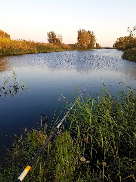 Paysage du soir à la rivière et canne à pêche