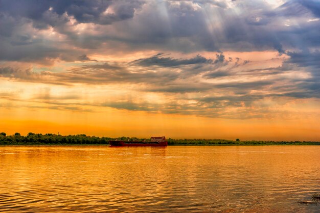 Paysage du soir de la rivière avec un pétrolier dessus