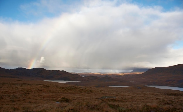 paysage écossais atmosphérique avec arc-en-ciel et nuages