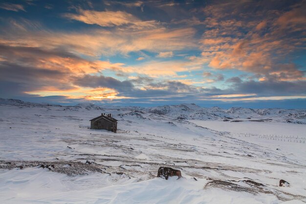 Paysage enneigé avec vieille maison en bois