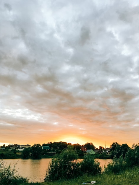 Paysage d'été au bord d'un étang au soleil couchant