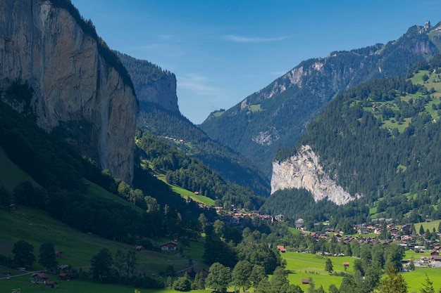 Paysage d'été du magnifique village de Lauterbrunnen avec la célèbre cascade de Staubbach dévalant la falaise rocheuse et les chalets dans la vallée verdoyante de l'Oberland bernois Suisse