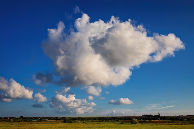 Paysage d'été Maisons rurales sur le terrain sous un ciel bleu avec des nuages blancs Pastorale