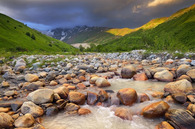 Paysage d'été avec la rivière de montagne. Nuages noirs sur une vallée de montagne. Zemo Svaneti, Géorgie