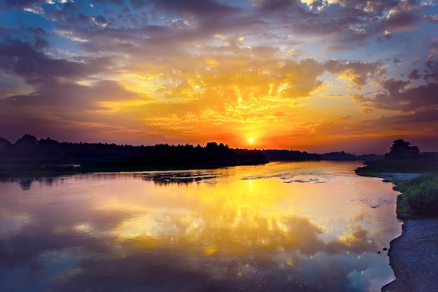 Paysage fluvial d'été avec lever de soleil multicolore