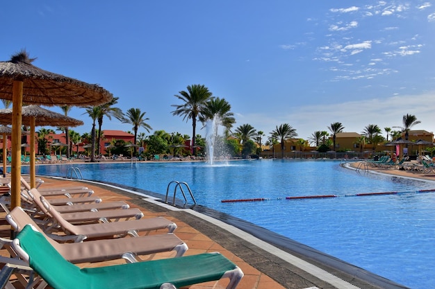 paysage d'une grande piscine avec de l'eau bleue dans une journée d'été à l'hôtel