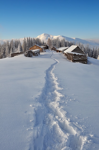 Paysage d'hiver avec un chemin vers le village de montagne des bergers