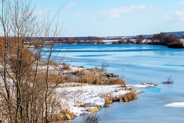 Paysage d'hiver avec forêt au-dessus de la rivière